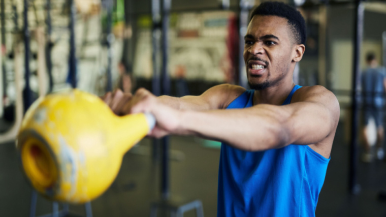 person straining while performing kettlebell exercise