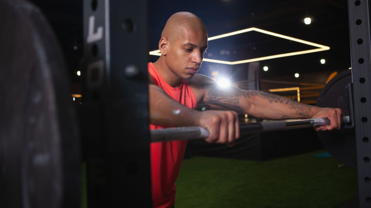 person in gym preparing to lift barbell