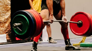 Muscular person doing deadlift in powerlifting contest