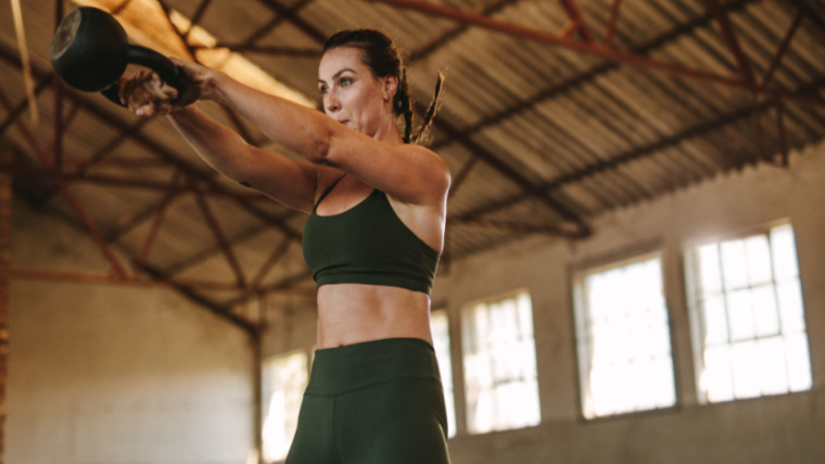 person in gym training with kettlebell