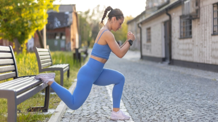 person outdoors performing leg exercise on street