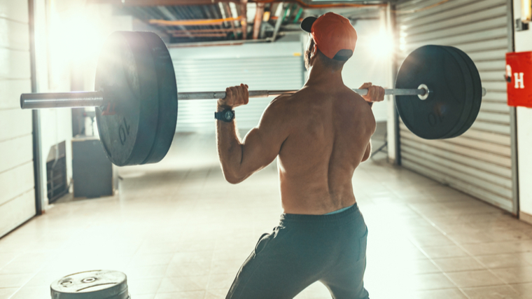 Man performing heavy barbell shoulder press