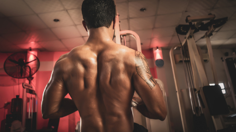 Bodybuilder in gym performing back exercise