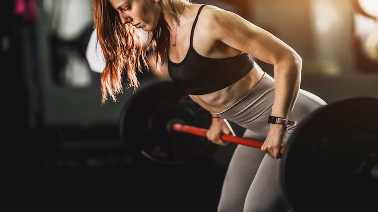 Person with long hair performing barbell row