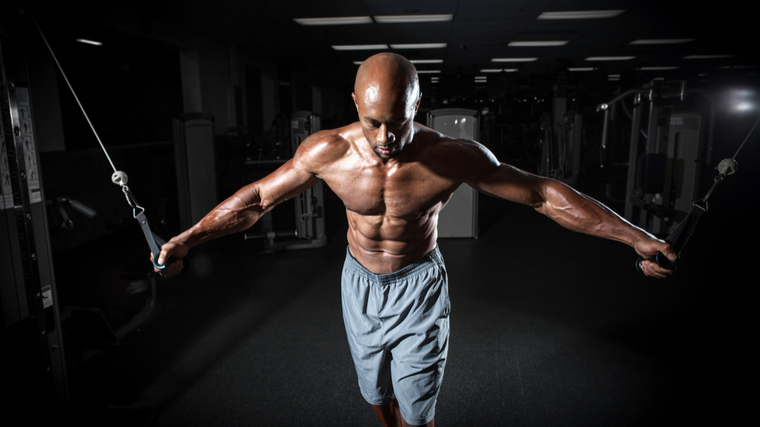 Man in gym performing cable chest exercise