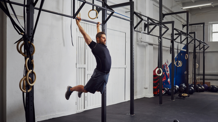 Man swinging from pull-up bar