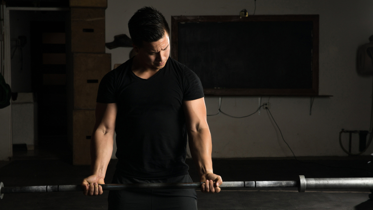 person in t-shirt holding barbell