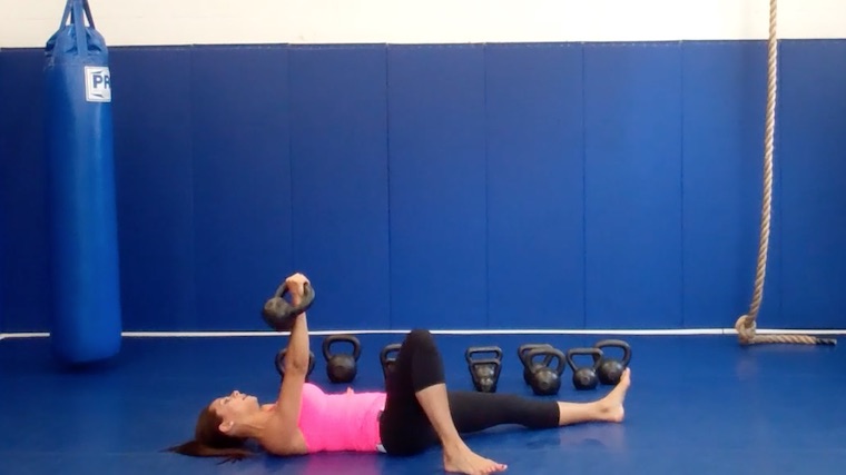 long-haired person in gym on floor with weight